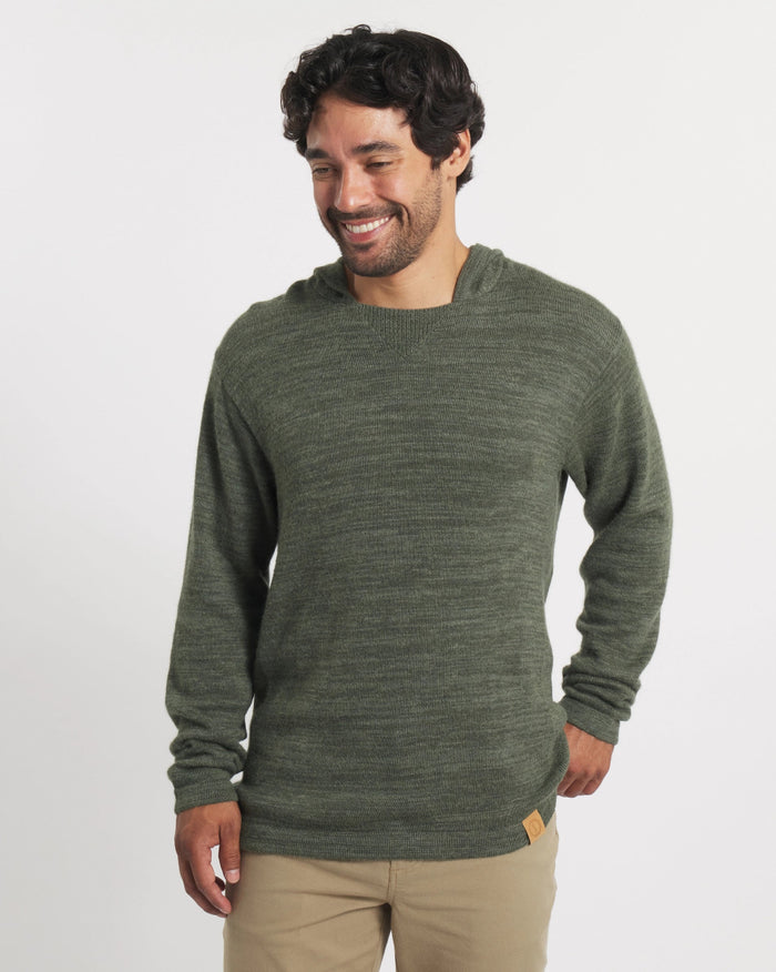 Front view of The Hoodie alpaca sweater in eucalyptus dark green on model showing relaxed fit and hood on white background