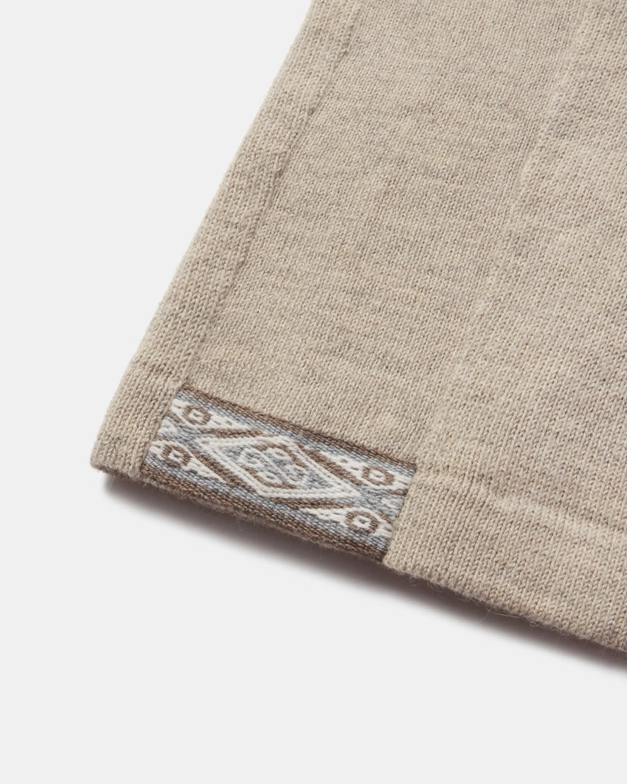 Close-up of hem of The Original Crew alpaca crewneck sweater showcasing jacquard-pattern inner hem detail in pebble color on white background