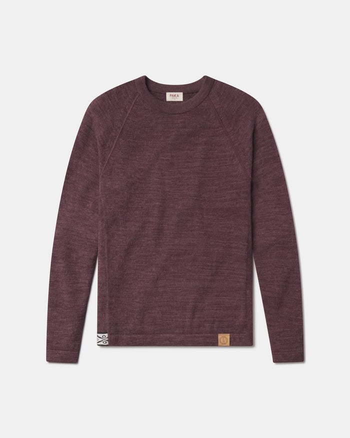 Front view of The Original Crew alpaca sweater in raisin showing raglan sleeves and leather hem patch on gray background
