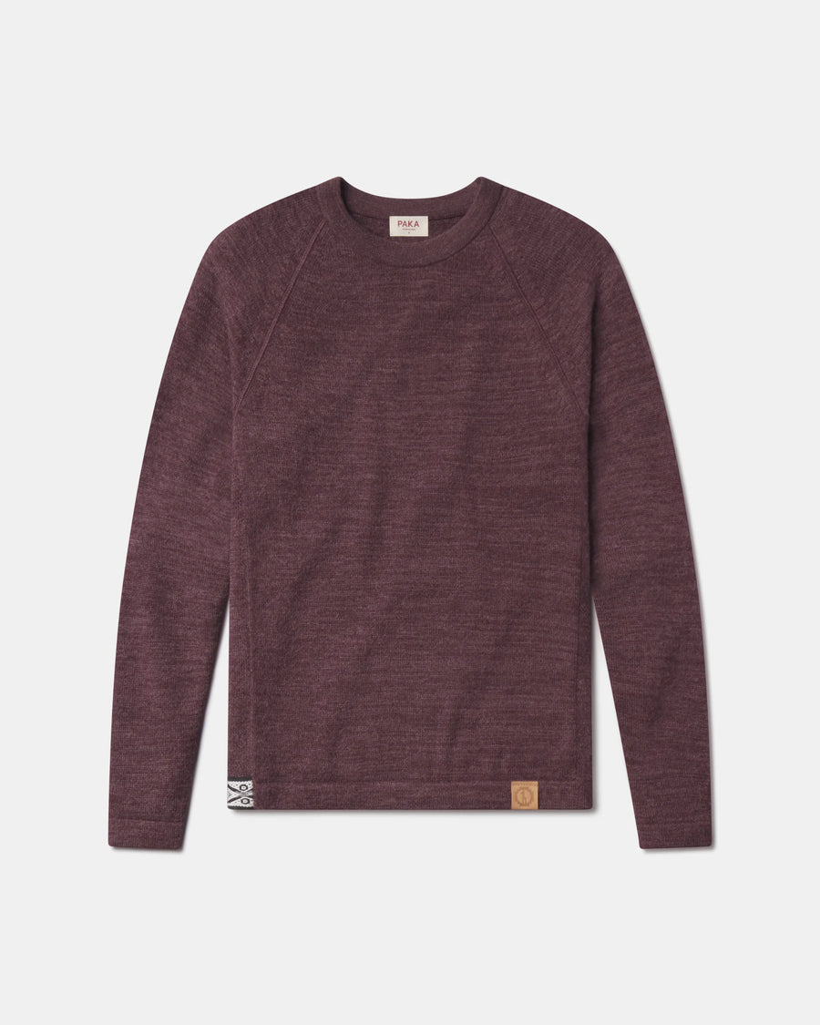 Front view of The Original Crew alpaca sweater in raisin showing raglan sleeves and leather hem patch on gray background