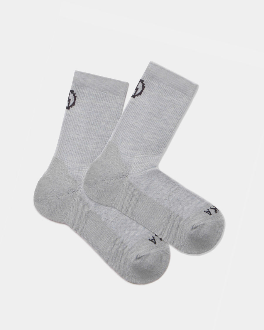 Flat lay of Trail 3/4 crew socks in light gray showcasing cushioned sole and black PAKA logo on cuff and toe on white background