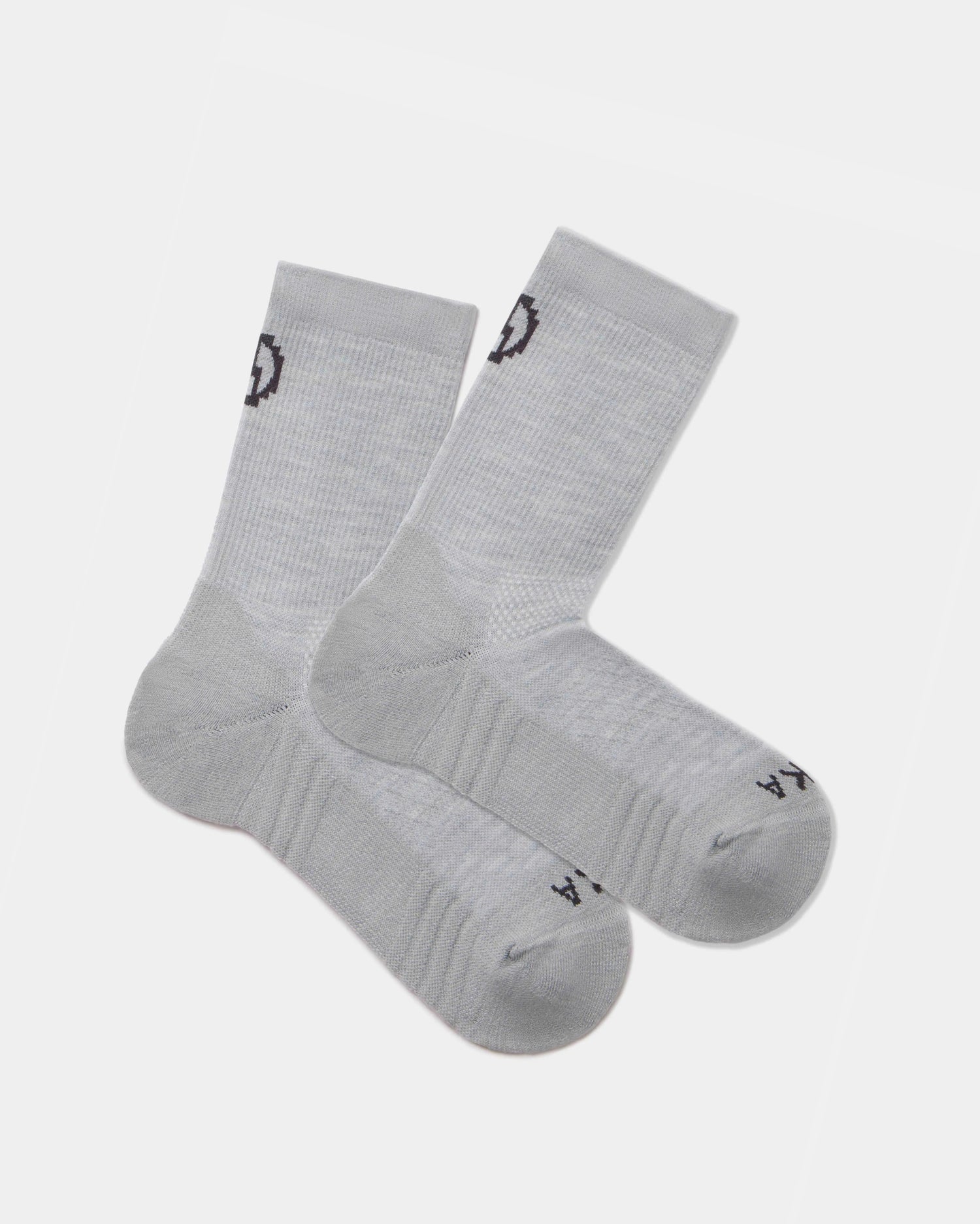 Flat lay of Trail 3/4 crew socks in light gray showcasing cushioned sole and black PAKA logo on cuff and toe on white background