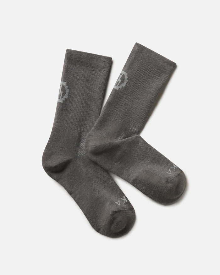Flat lay of Trail Crew Socks in dark gray showing crew height, cushioned footbed and PAKA logo on white background
