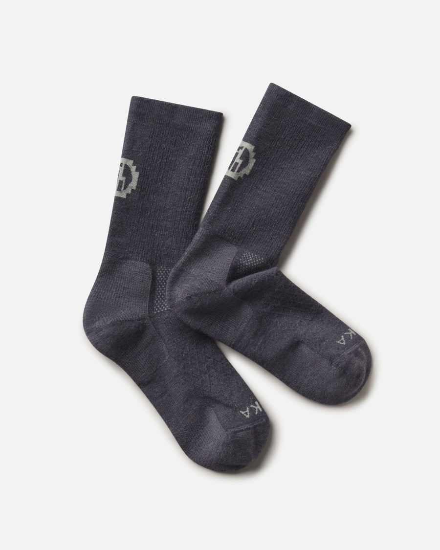 Top-down view of Trail Crew Socks showcasing charcoal blue color, crew height, cushioned footbed and PAKA logo on white background