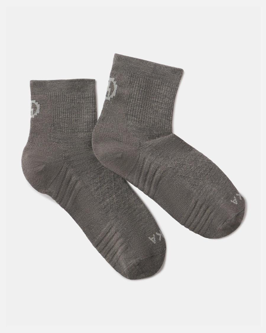 Angled view of Trail quarter crew socks in charcoal with cushioned sole, ribbed arch and ankle cuff on white background