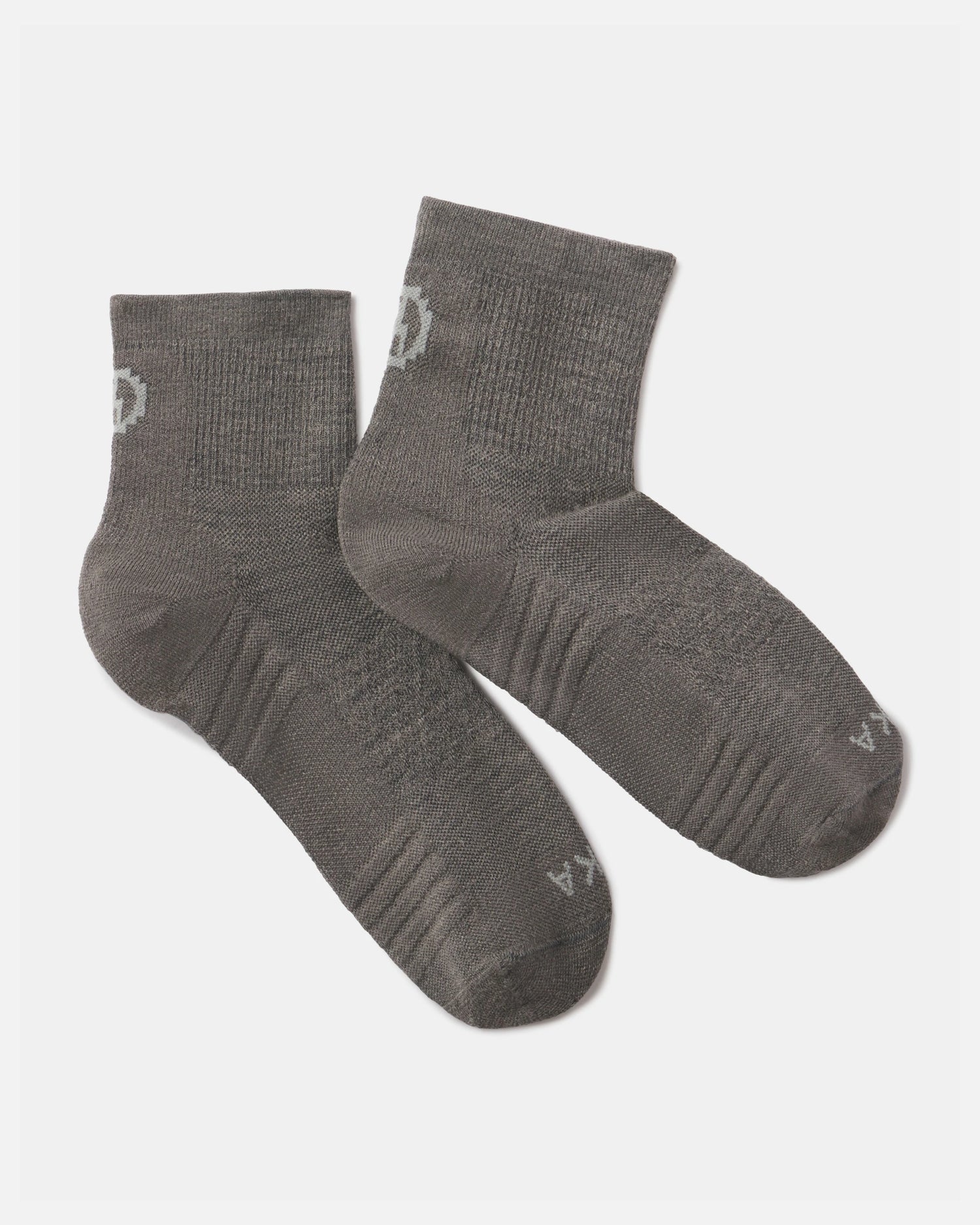 Angled view of Trail quarter crew socks in charcoal with cushioned sole, ribbed arch and ankle cuff on white background