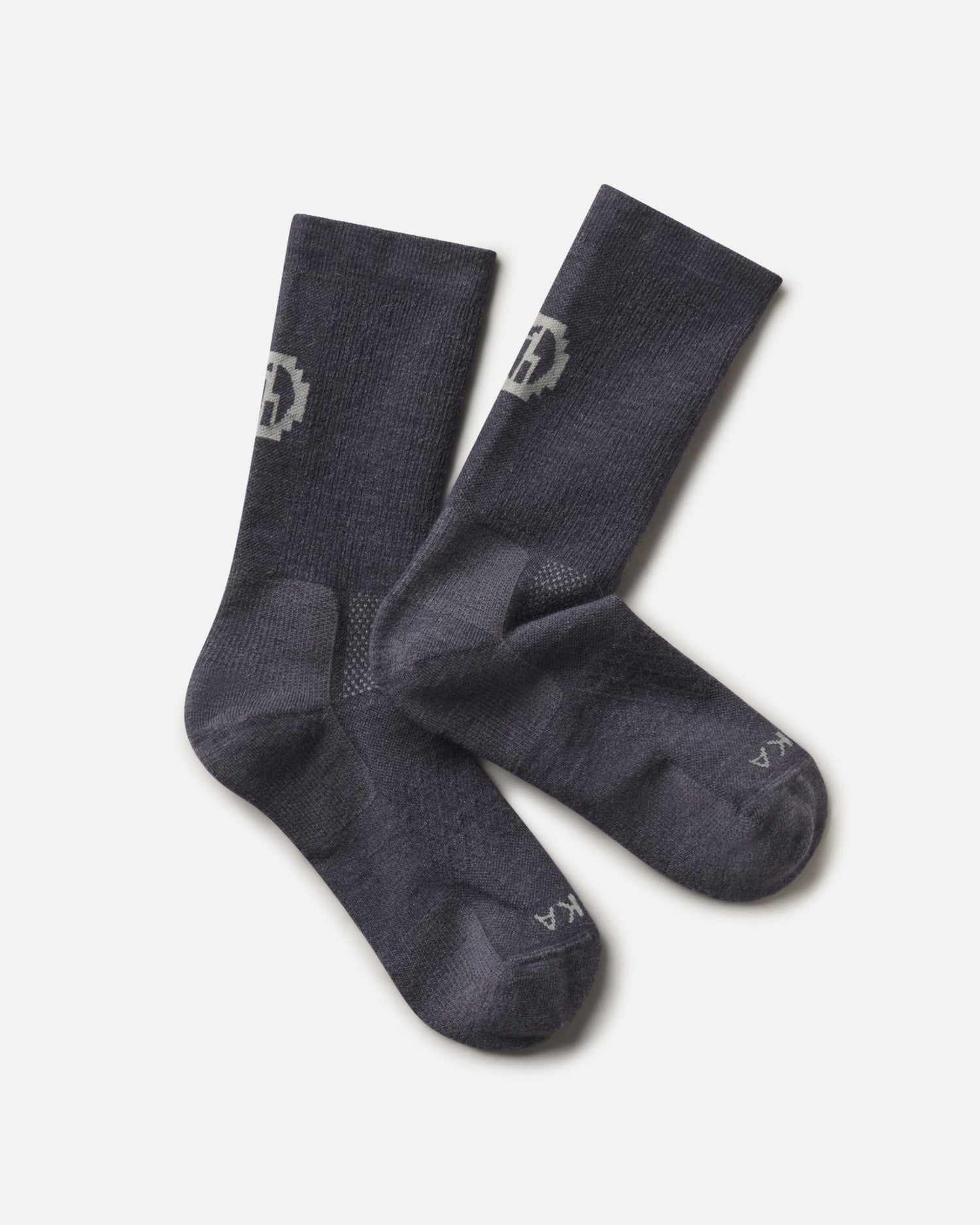 Top-down view of Trail Crew Socks showcasing charcoal blue color, crew height, cushioned footbed and PAKA logo on white background