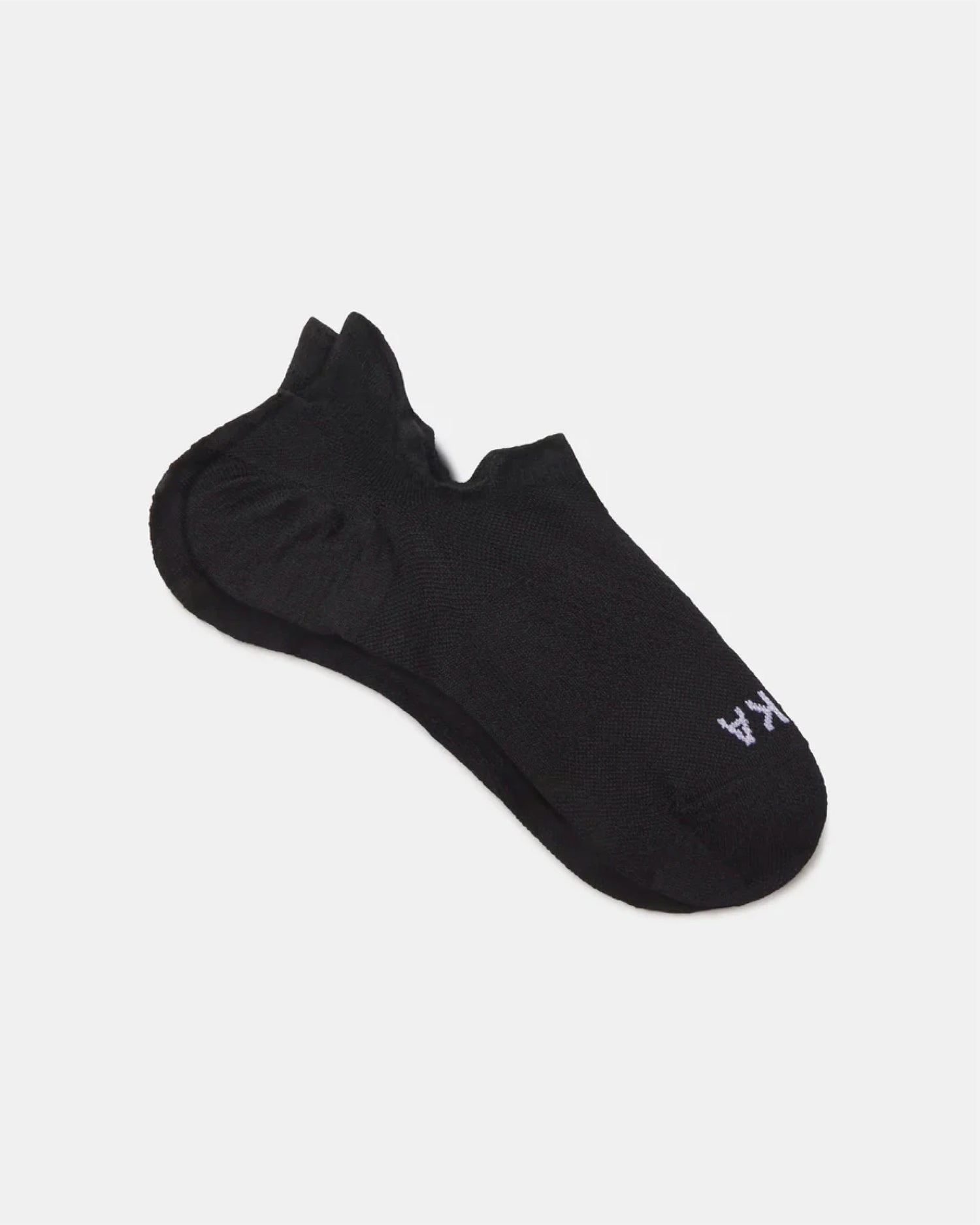 Flat lay of Trail Ankle Socks showcasing low-cut ankle silhouette, cushioned heel, and PAKA logo on white background