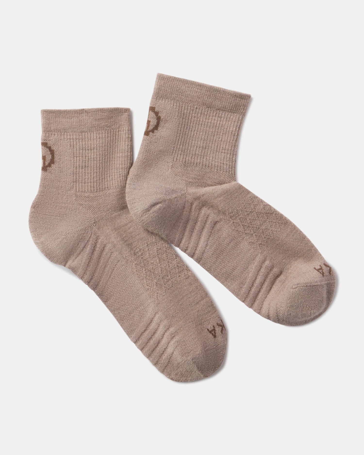 top view of Trail 1/4 Crew socks in taupe showing cushioned sole, ribbed cuff and small PAKA logo on white background