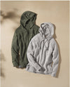 Flat lay of two PAKA women’s hoodies in olive and light gray, showing soft alpaca knit and hood