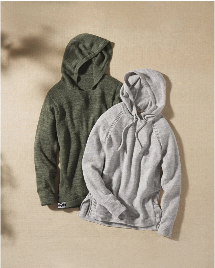 Flat lay of two PAKA women’s hoodies in olive and light gray, showing soft alpaca knit and hood