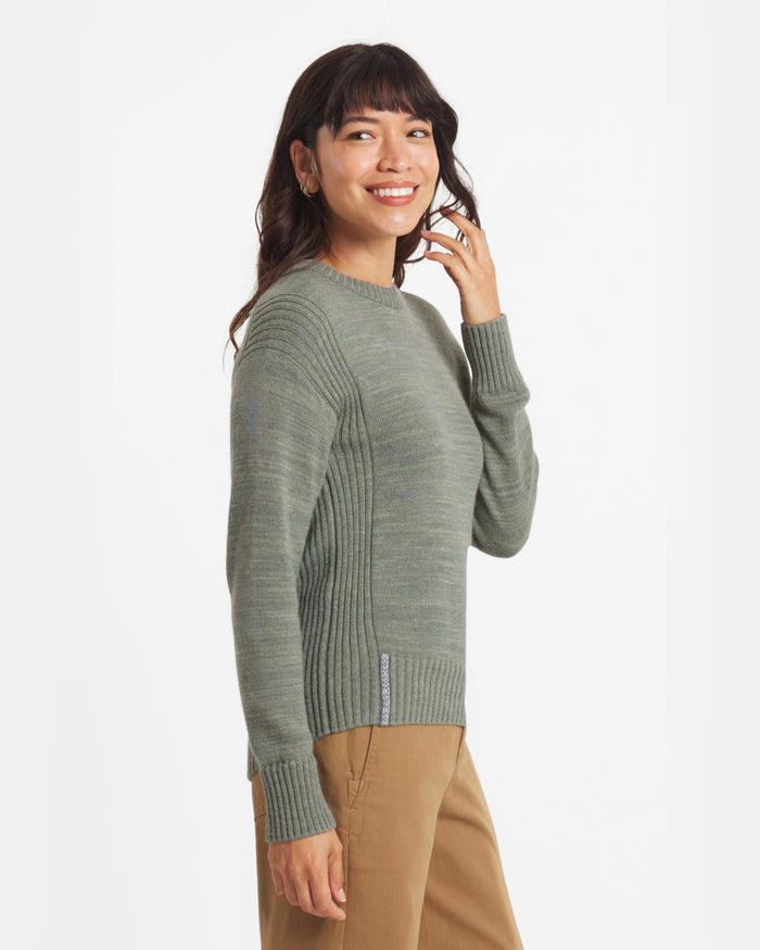 Side view of Women’s Original Crew alpaca crewneck showing ribbed side panels and cuffs on a model against a white background