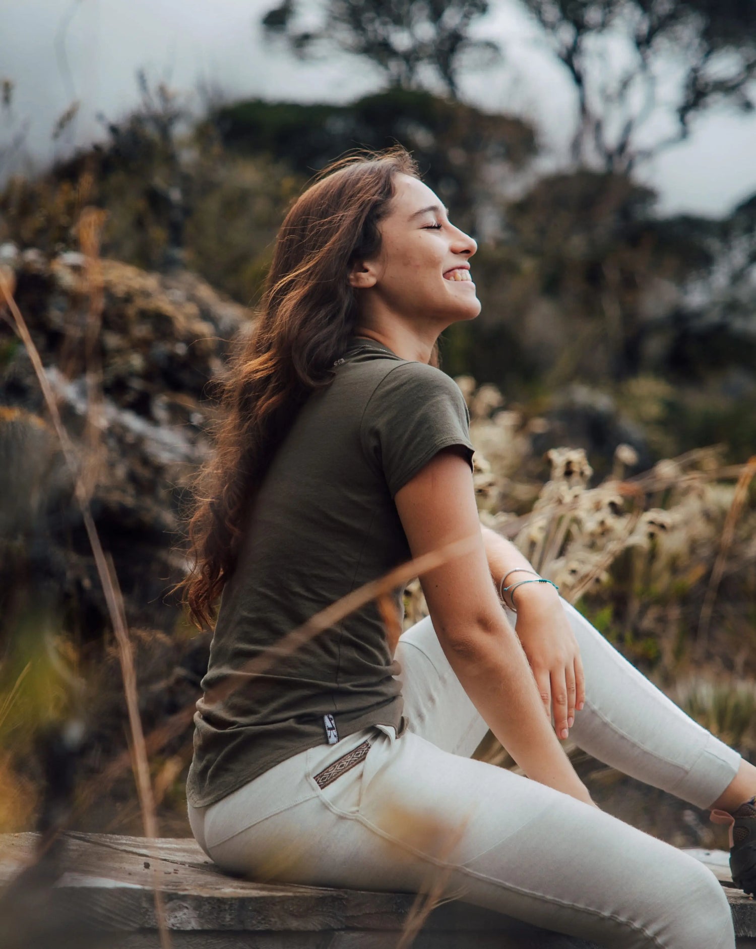 Close Up of Woman Named Sofia Sitting on Wood Dock Wearing Andean Moss / Dark Green Natural Alpaca Fiber T-Shirt – PAKA Apparel