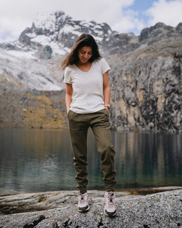 Front view of Women’s Breathe Jogger in Andean Moss showing tapered fit, elastic cuffs and pockets with lake backdrop