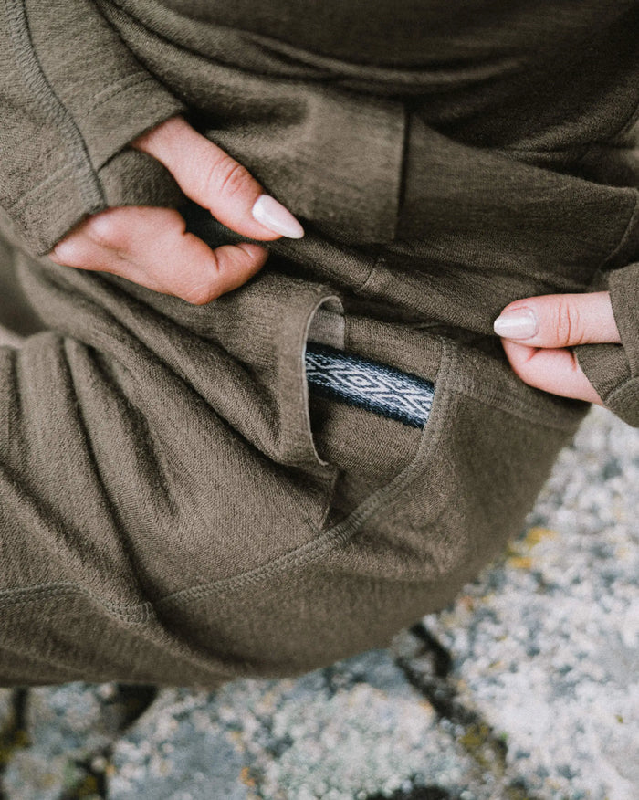 Close-up of Women’s Breathe Jogger in Andean Moss showcasing pocket with patterned inner lining against rocky ground