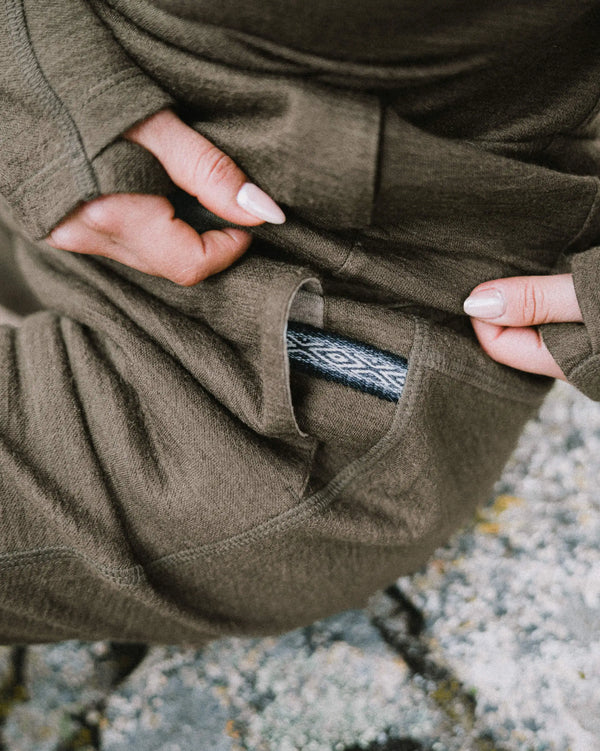 Close-up of Women’s Breathe Jogger in Andean Moss showcasing pocket with patterned inner lining against rocky ground