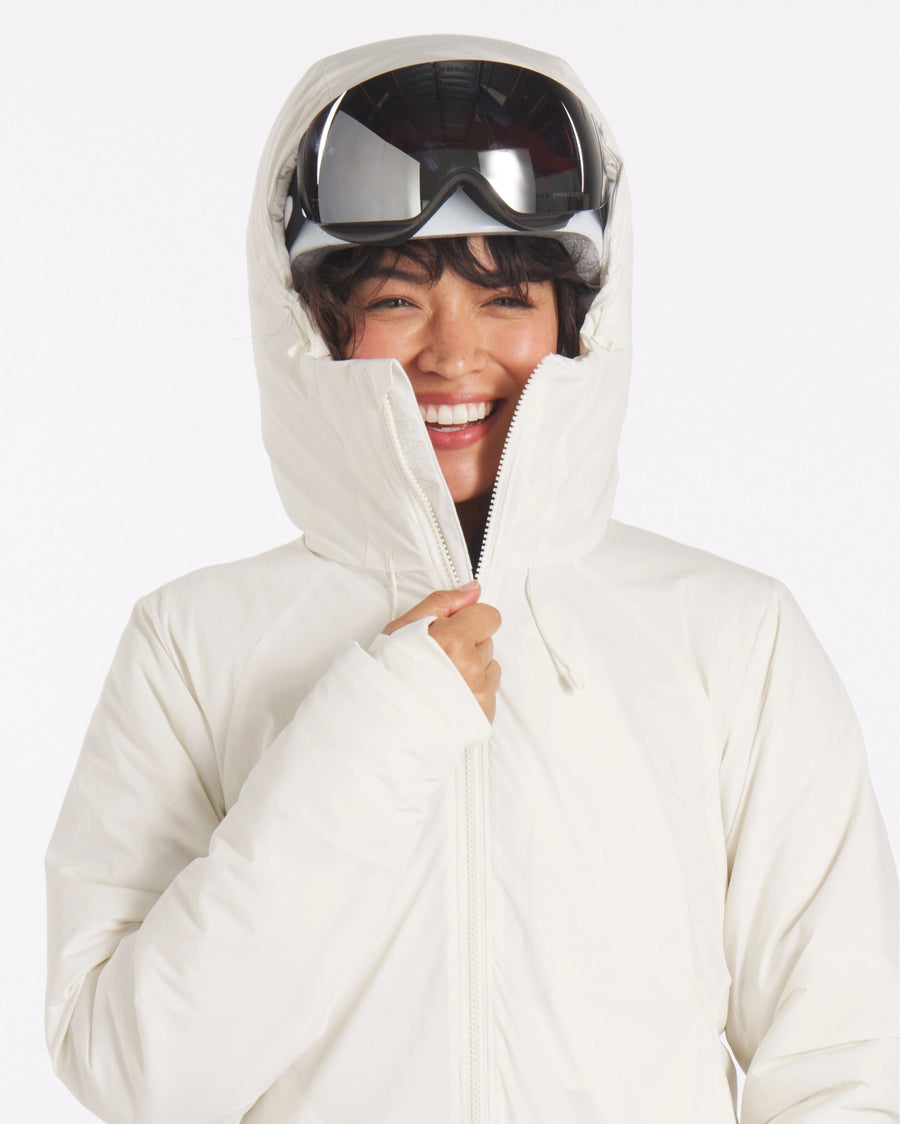 Front view of The Original Women’s Apu Parka in ivory, hood up showing high padded collar and full-length zipper
