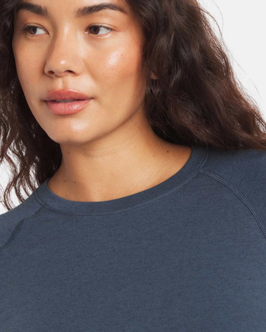 Front close-up of Women’s Sol Crew long-sleeve sun shirt in navy showing crew neck and raglan seam on model, white background