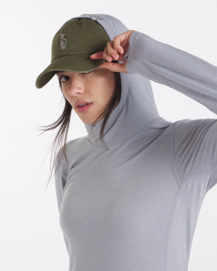 Three-quarter front view of Women’s Sol Hoodie in light gray with hood up and thumbhole sleeve, fitted on model against white background
