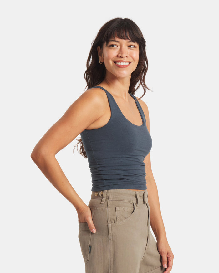 Three-quarter right view of Women’s Essential Tank showing scoop neckline, wide straps, built-in shelf bra and cropped close-to-body fit on light gray background