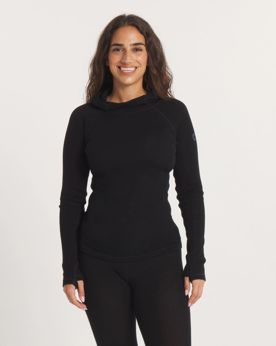 Front view of Women’s Thermal Hoodie in black on model showing slim fit, hood, thumbhole sleeves against white background