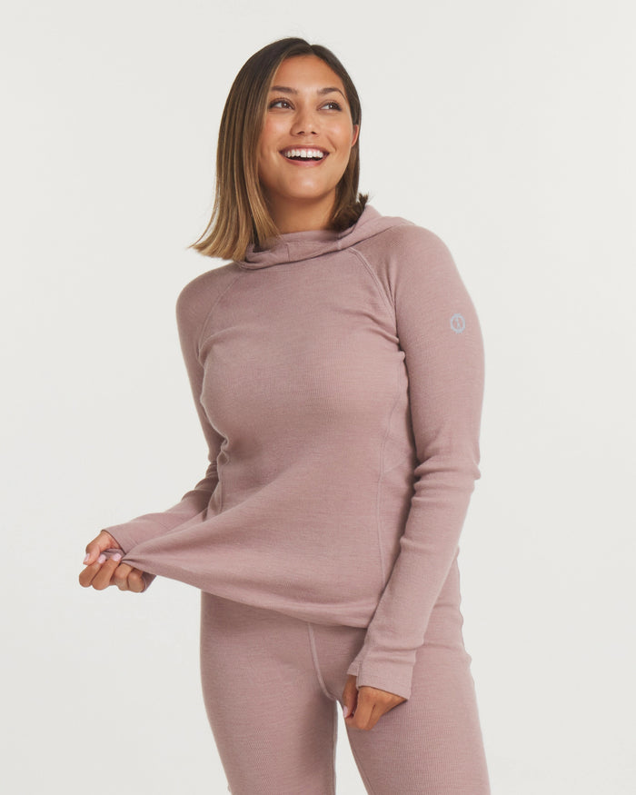 Front three-quarter view of Women’s Thermal Hoodie in magnolia pink on model, fitted with thumbhole cuffs and hood, white background