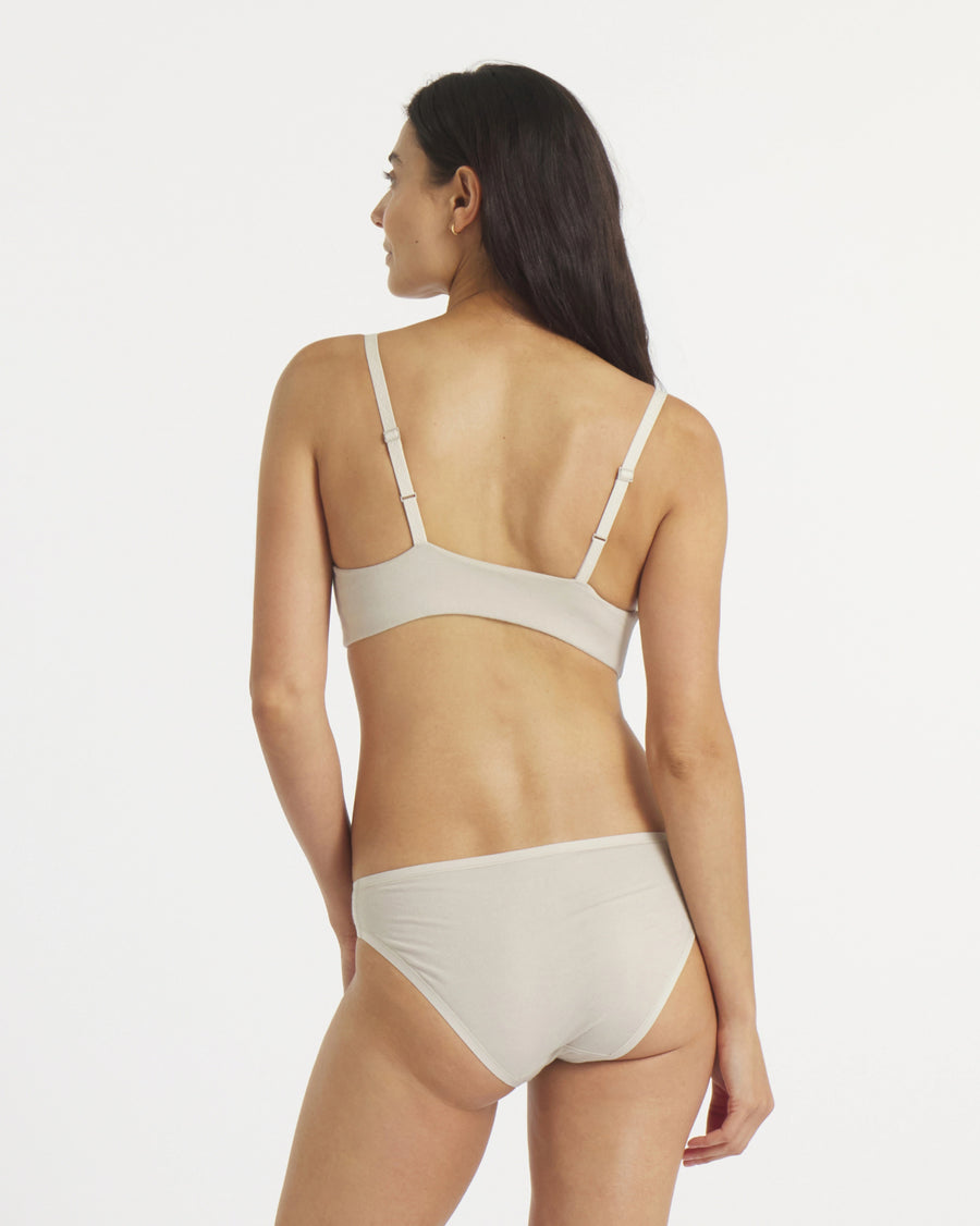 Back view of Women’s Essential Triangle Bralette in bone on model showing adjustable straps and smooth elastic band against white background