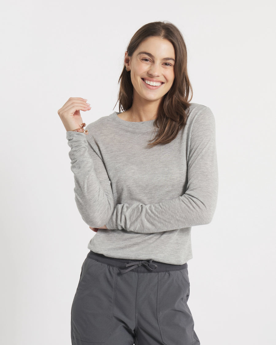 Front view of Women’s Aire Long Sleeve shirt on model showcasing slim fit, lightweight heather grey fabric on white backdrop
