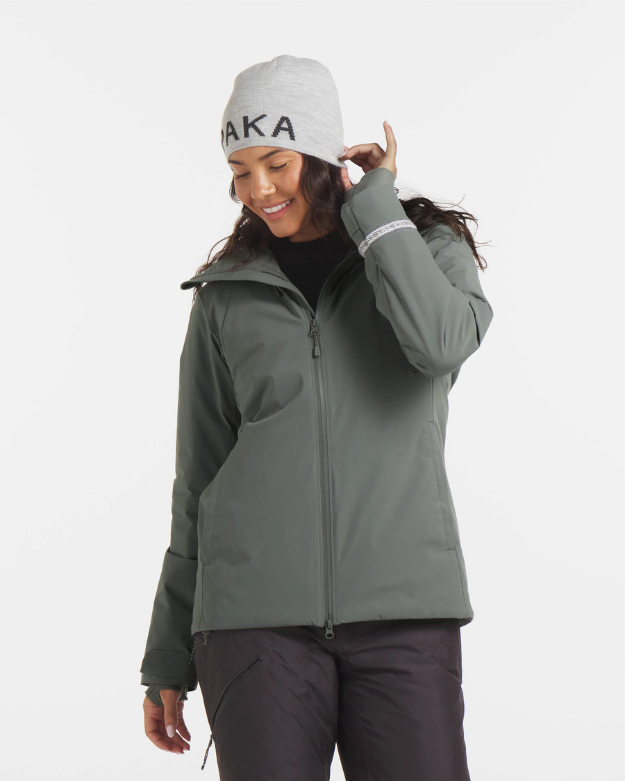Three-quarter front view of Women’s Apu Parka in eucalyptus showcasing helmet-compatible hood, two-way front zipper, and adjustable cuffs on white background