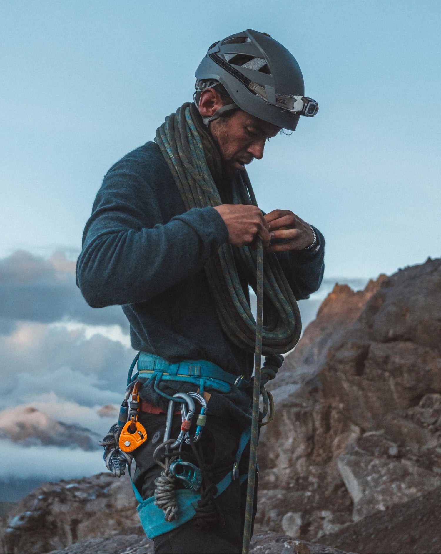 Man in blue alpaca sweater climbing 
