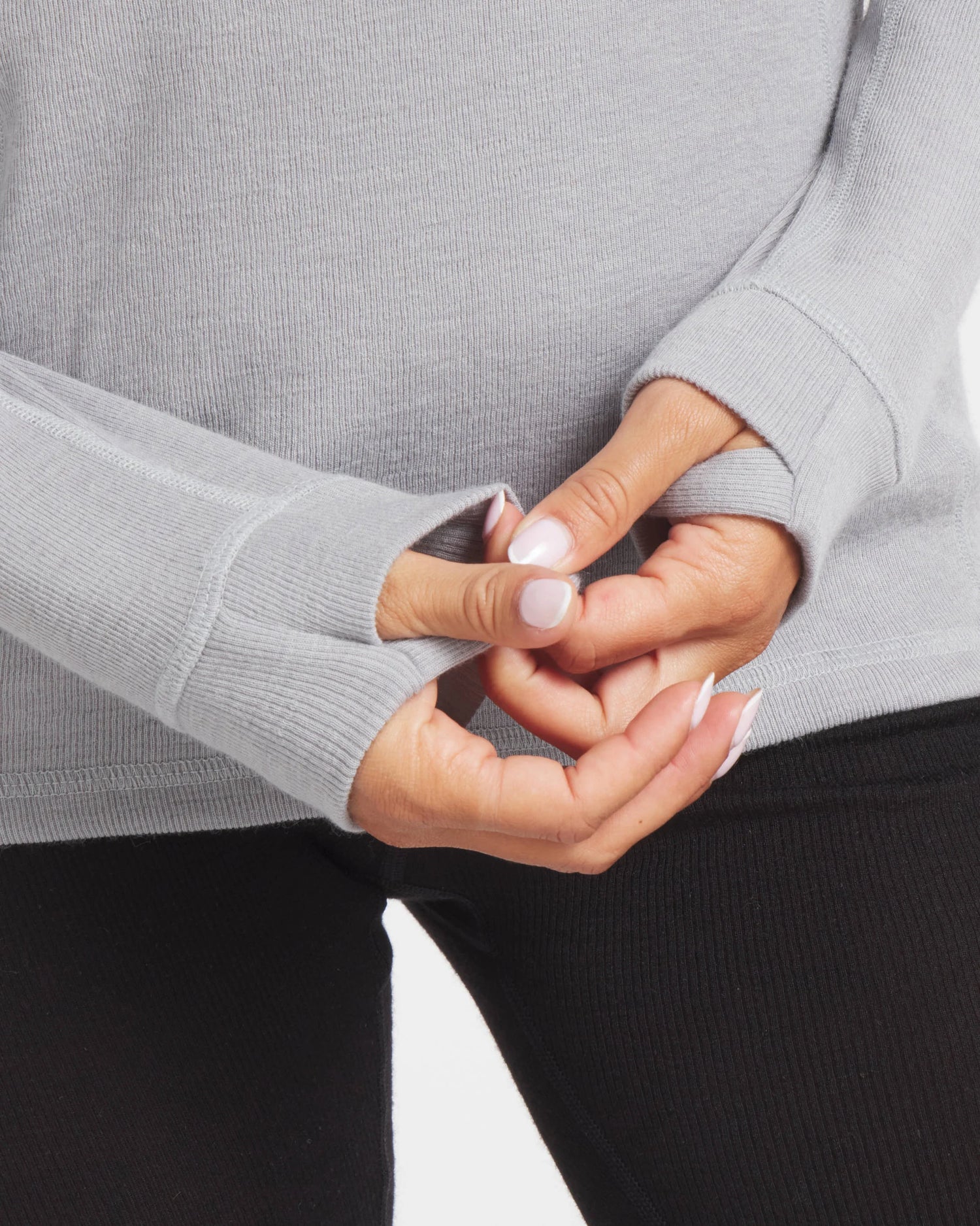 Close-up of Women’s 1.0 Thermal Crew in light grey showing thumbholes on the sleeves against a white background