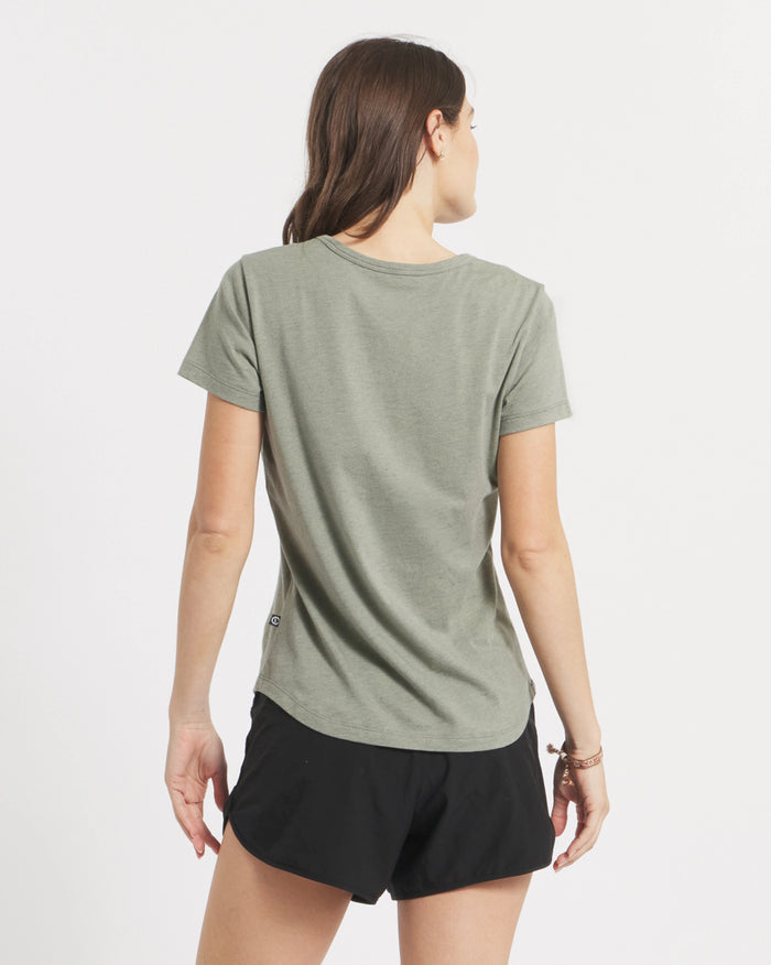 Back view of Women’s Essential Tee in willow showing short sleeves, crewneck, and curved hem on white background