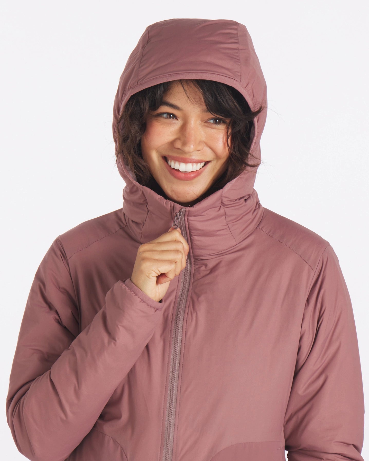 Smiling Woman with Hood Up and Hand on Zipper of Women's Apu Lightweight Puffer Jacket in Rose / Dark Pink – PAKA Apparel