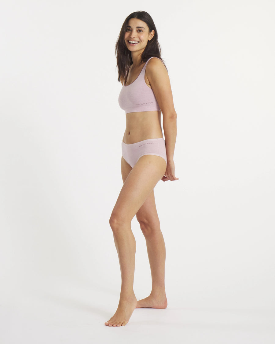 Side view of Women’s Essential Scoop Bralette and matching briefs in lilac on a model, showing scoop neckline and elastic logo band on a white background