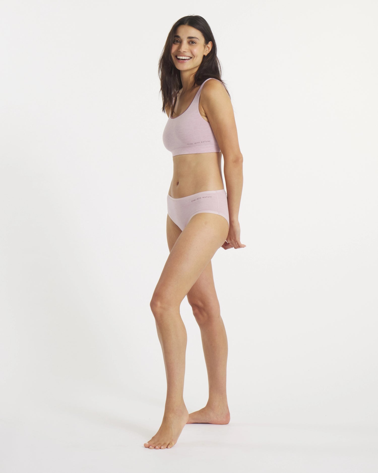 Side view of Women’s Essential Scoop Bralette and matching briefs in lilac on a model, showing scoop neckline and elastic logo band on a white background