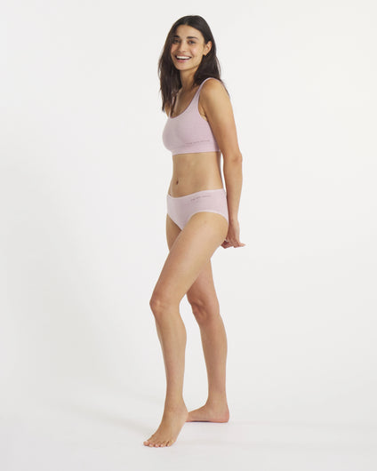 Side view of Women’s Essential Scoop Bralette and matching briefs in lilac on a model, showing scoop neckline and elastic logo band on a white background
