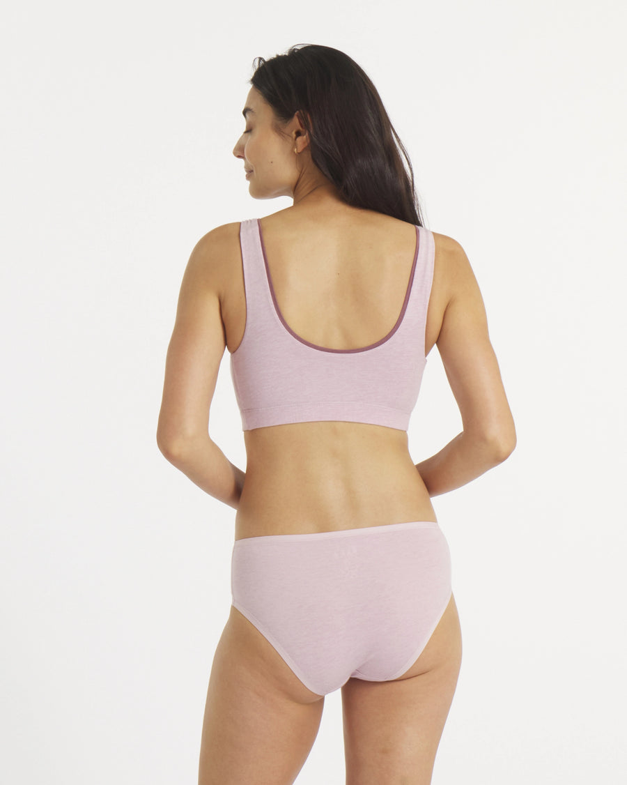 Back view of Women’s Essential Scoop Bralette in lilac on model showing scoop back and wide supportive band on white background