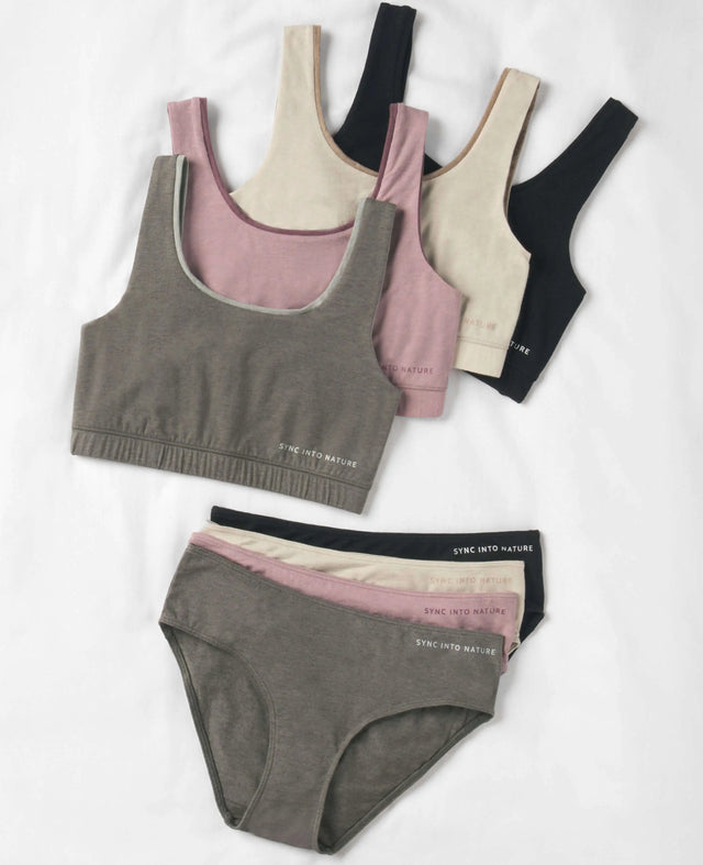 Flat lay of alpaca bralettes and matching briefs showing rib-knit texture in neutral tones on white background
