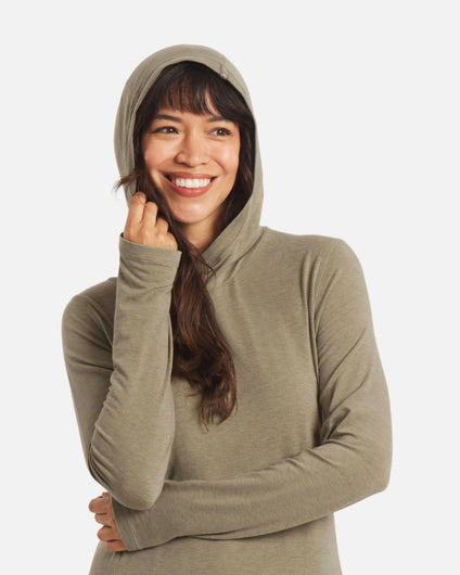 Three-quarter view of Women’s Sol Hoodie in Elm on model, hood up and long sleeves with hidden thumbholes, white background