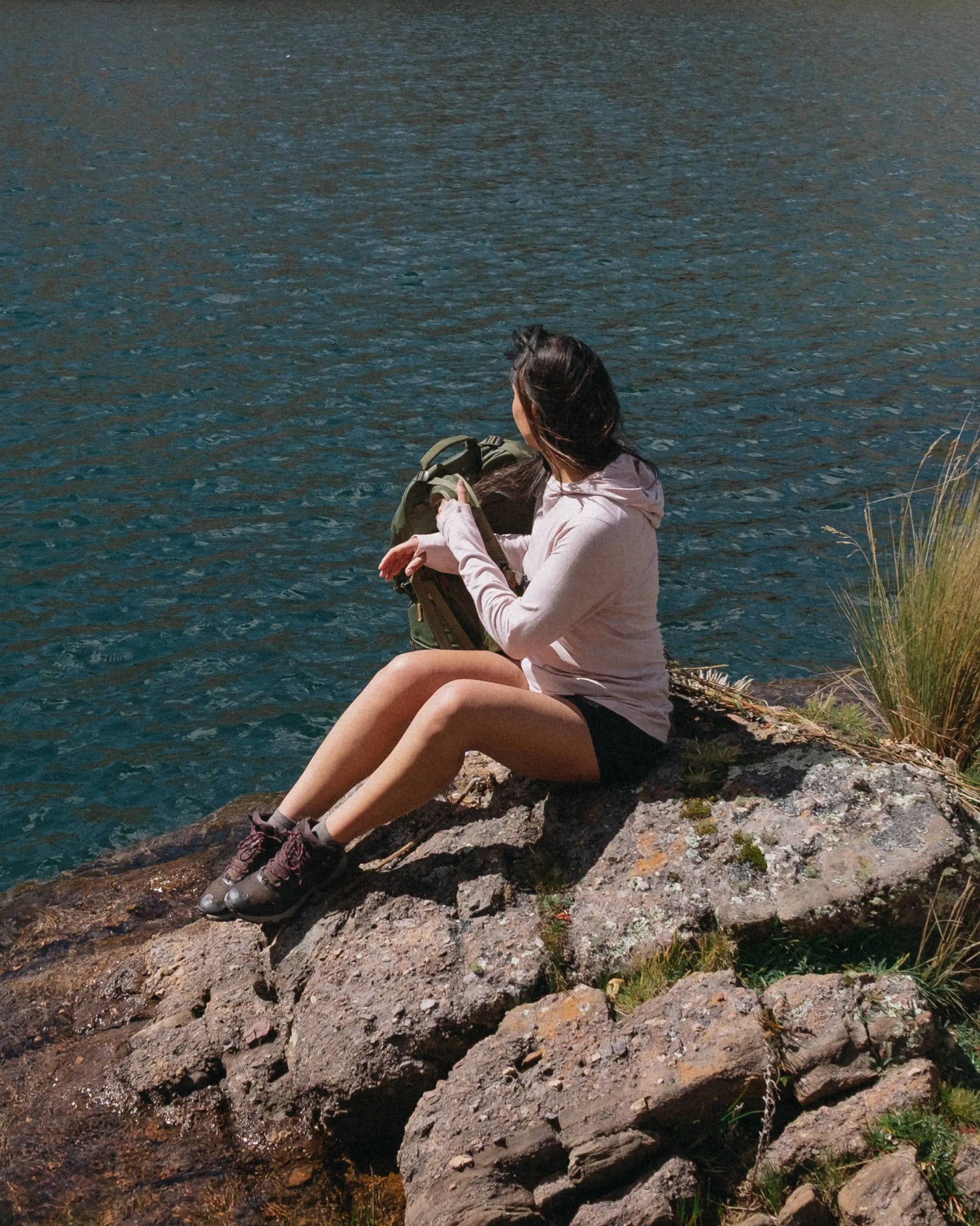 Women Named Chaska Sitting on Rock Overlooking Water in Lilac / Light Pink Sol Women's Sun Hoodie – PAKA Apparel