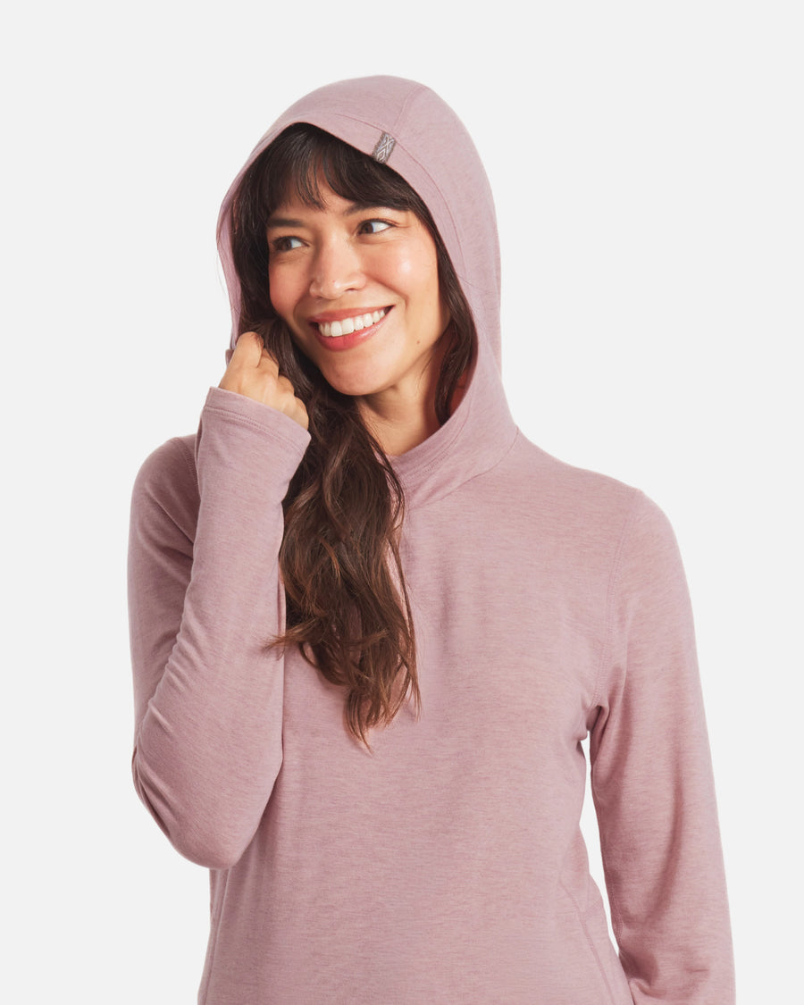 Front view of Women’s Sol Hoodie in Woodrose on model with hood up and visible thumbhole, regular fit, white background