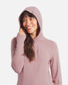 Front view of Women’s Sol Hoodie in Woodrose on model with hood up and visible thumbhole, regular fit, white background