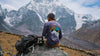 Man wearing a purple Explore Peru long-sleeve tee standing before Ausangate mountain in the Peruvian Andes