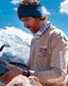 A traveler wearing one of our Explore Peru shirts in front of a snowy mountain in Peru