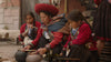 Quechua weaver showing two girls the ancient alpaca dyeing process