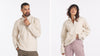 Two models wearing PAKACLOUD alpaca fleece jackets standing on a rocky trail