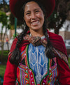 Smiling Peruvian woman wearing colorful traditional handwoven clothing outdoors