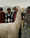 Alpaca farmers standing with an alpaca. 