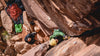 Two women climbing rocks in their Pakafill puffer jackets