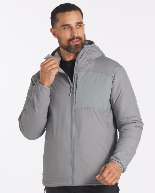 Front view of Men’s Apu puffer jacket worn by model, hood, chest zip pocket, two-tone storm grey, PAKAFILL insulation